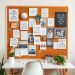 A corkboard filled with motivational quotes, images, and notes in a feminine home office setting.
