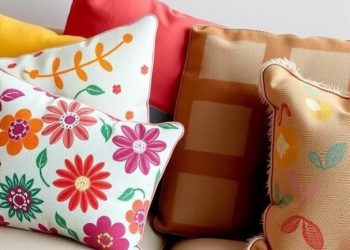 A collection of colorful throw pillows on a couch, featuring floral patterns and various textures.
