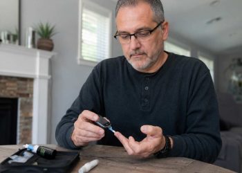 Man checking his blood sugar with a blood sugar monitor