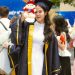 a woman in a graduation gown holding a stuffed animal
