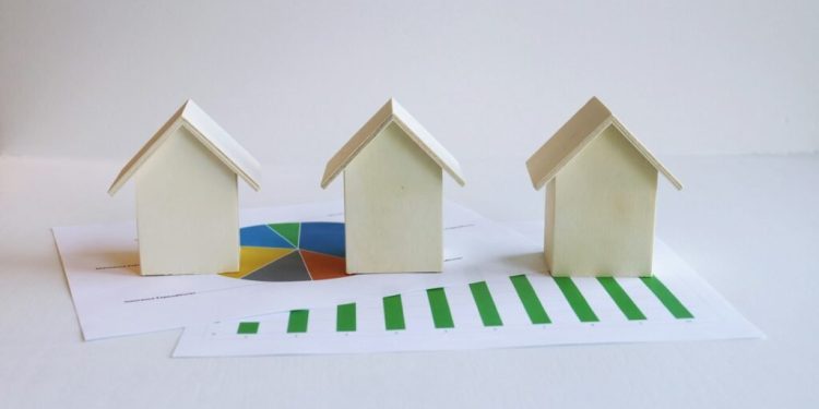 three small houses sitting on top of a piece of paper