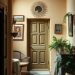 A cozy hallway with warm colors, wooden beams, plants, and artwork.