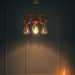 A stylish chandelier and candle on a desk in a feminine home office setting.