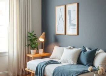 A cozy home office featuring a daybed, dark gray wall, light curtains, and blue accents.