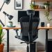 A modern home office setup featuring an ergonomic chair, desk, and plants.