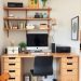 A small home office setup with a desk, computer, and organized shelves.