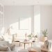 A minimalist living room with neutral colors, featuring soft beige sofas, a round coffee table, and a potted plant.