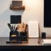 A modern desk setup featuring stylish desk organizers, a lamp, and a clean workspace.