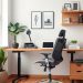 A modern home office featuring an ergonomic chair, a sleek desk, and decorative plants.