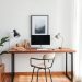 A modern home office with a floating desk, computer, and stylish chair.