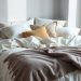 A cozy bedroom with layered textiles, featuring fluffy pillows and a warm throw blanket.