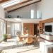 A bright and airy open concept living room with high ceilings, large windows, and a cozy seating area.
