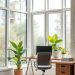 A bright home office with large windows, plants, and a wooden desk.