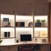 A well-lit home office with built-in shelves, featuring a computer, books, and decorative plants.