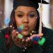 a woman in a graduation cap blowing bubbles