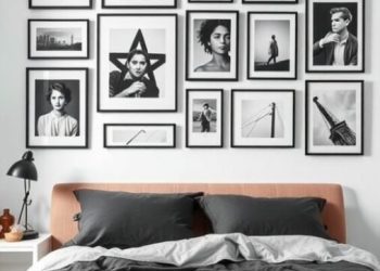A stylish bedroom featuring a bed with dark bedding and a wall adorned with black and white photography in various frames.