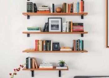 Floating shelves displaying books and decor in a minimalist bedroom