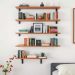 Floating shelves displaying books and decor in a minimalist bedroom