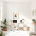 A minimalist home office with a neutral color palette, featuring a desk, plants, and natural light.
