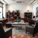 A stylish masculine home office featuring dark wood furniture and leather chairs.
