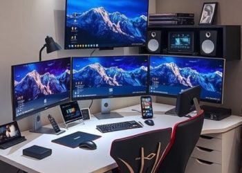 A modern tech-friendly workstation with three monitors, ergonomic chairs, and stylish LED lighting.