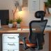 A cozy desk setup featuring an ergonomic chair and a stylish desk with plants and decor.