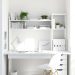 A bright and airy home office with white walls, a white desk, and green plants.