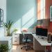 A small home office featuring a blue and coral color scheme with plants and modern furniture.