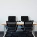 A double desk setup with two black office chairs, designed for collaboration.