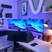 A modern tech-savvy home office with dual monitors, a sleek desk, ambient lighting, and organized shelves.